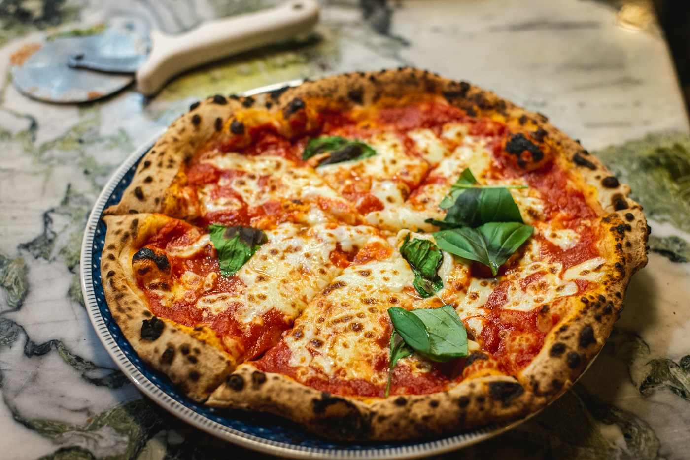 Frisch gebackene Pizza mit Tomaten, Mozzarella und Basilikum
